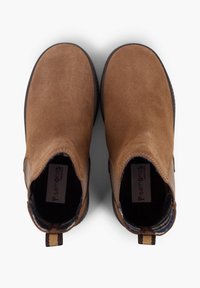 Botine din suede maro cu vârful rotunjit, panouri laterale elastice și un tab pentru tragere cu dungi în spate. Textură moale și design minimalist.