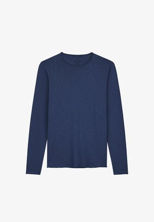 Tumedat laevad särgid, pikad varrukad, tekstuuriga kangast, ümmarguse kaelusega ja lõdva lõikega, millel on toored ääred varrukaotsades ja alapoolses osas.