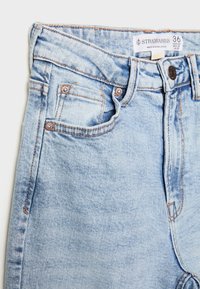 Ljusblå denimjeans med hög midja, med kopparaccenter, fem fickor och synlig sömnad. Tillverkade av Stradivarius.