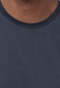 Marineblaue Rundhalsausschnitt-T-Shirts aus weichem, strukturiertem Stoff mit glatter Oberfläche. Besitzt einen engen Ausschnitt und minimalistisches Design.
