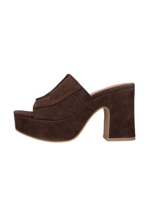 Mule platform in suede marrone con bordatura intrecciata, dettagli con frange e tacco a blocco su sfondo bianco.