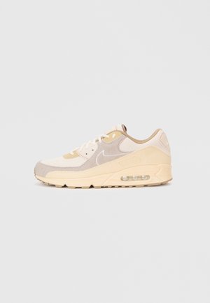 Beżowo-kremowe buty Nike Air Max z siateczkowymi i zamszowymi panelami, widocznym systemem amortyzacji powietrznej oraz sznurowaniem na białym tle.