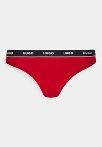 Czerwony dół bikini z czarnym elastycznym pasem z napisem "HUGO" w kolorze białym. Gładki materiał, minimalne przykrycie i prosty design.