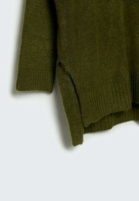 Pull tricoté vert olive avec poignets côtelés et fentes latérales. Texture douce, design décontracté et coupe ample. Aucun élément métallique visible ni motifs.