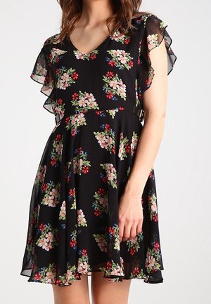 Zwarte jurk tot op de knie met meerkleurige bloemenprint, korte wijd uitlopende mouwen en een getailleerde taille op een staand persoon.