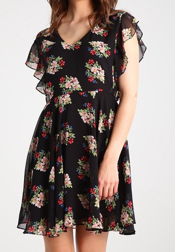 Robe noire longueur genou avec imprimé floral multicolore, manches courtes évasées et taille cintrée sur une personne debout.
