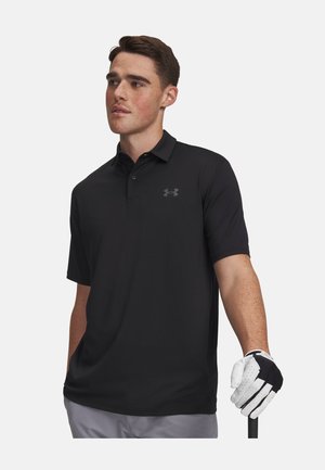 Noormees musta polo ja valge golfikindaga hoiab golfikeppi tavalise tausta ees.