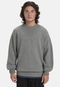 Grauer, gestrickter Pullover mit Rundhalsausschnitt und gerippten Bündchen und Saum. Weiche Textur mit einem leicht lockeren Schnitt.