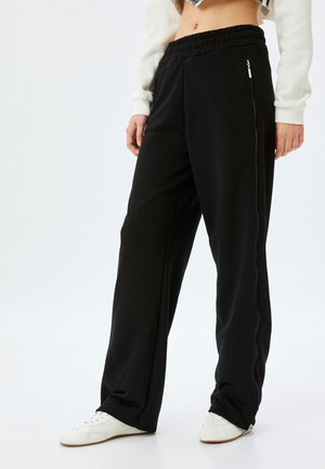 WIDE - Trousers - black