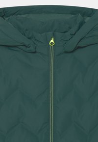 Dunkelgrüne isolierte Jacke mit Kapuze, ausgestattet mit einem zentralen Reißverschluss in leuchtendem Gelb und einer glatten, strukturierten Stoffoberfläche.