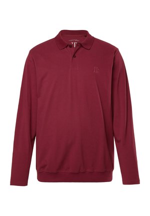 Burgundin pitkähihaine polo-paita, joka on valmistettu pehmeästä puuvillasta. Paidassa on kolmen napin lista ja hillitty logo-ommel rinnassa.