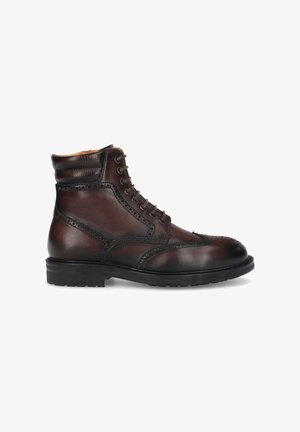 Brown leather ankle boot with a round toe, brogue detailing, lace-up front, and textured leather accents on the collar and sides. Black rubber sole.