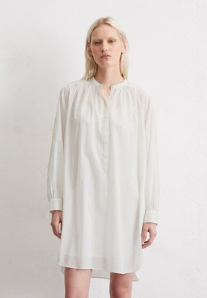Witte lange mouw jurk met een mandarinenkraag en knoopsluiting. Gemaakt van lichtgewicht stof, met een ontspannen pasvorm en gathered schouders.