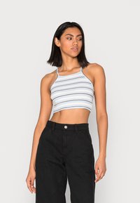 Top cropped listrado azul claro com relevo, apresenta riscas horizontais pretas, alças finas e decote quadrado. Combinado com calças pretas de cintura alta.