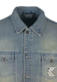 Svetlo modra jeans jakna s ostrim ovratnikom, sprednjimi gumbi, dvema prsnih žepoma z kovinskimi detajli in logotipom na levem žepu.