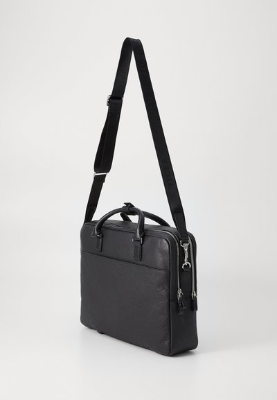 Sac à dos pour ordinateur portable en cuir noir, doté de deux poignées supérieures, d'une sangle réglable et de Ferrures en acier inoxydable. Présente une surface texturée et une fermeture zippée.