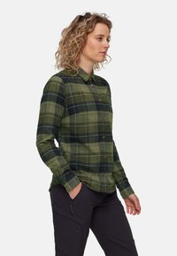 Grøn- og sortternet skjorte med lange ærmer og krave, udstyret med brune knapper og et blødt, tekstureret stof.