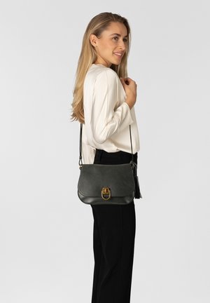 Gray leather crossbody bag with a flap and gold hardware, featuring a tassel accent. The bag has a rounded shape and smooth texture.