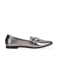 Zapatos planos metálicos plateados con punta afilada, que cuentan con una correa decorativa y detalle de hebilla en la parte frontal, y una suela baja negra.