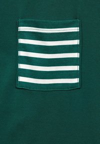 Mörkgrön skjorta med en fyrkantig ficka med vita horisontella ränder. Sättet är mjukt, designen är diskret och med enkla sömdetaljer.