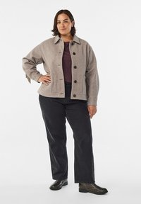 Light gray wool jacket with a collar and dark buttons, paired with black pants and dark ankle boots. Smooth texture and relaxed fit.