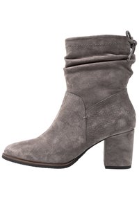 Šedá semišová kotníková bota s volným svrškem, špičatou špičkou a blokovým podpatkem. Disponuje jemným leskem a dekorativním prošitím.