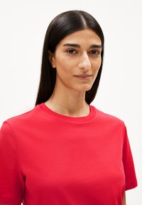 Rood T-shirt met korte mouwen van een gladde stof, met een klassieke ronde halslijn en een minimalistisch ontwerp zonder patronen of accenten.