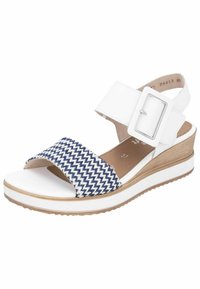 Sandale à plateforme blanche avec une sangle à motif zigzag bleu marine et blanc, boucle réglable et semelle texturée. Dispose d'un talon avec un accent bois.