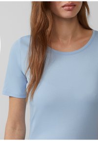 Lichtblauwe t-shirt met korte mouwen en ronde hals, met een gladde textuur en een slimfit ontwerp, dat minimale stikseldetails toont.