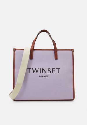 Sac fourre-tout en toile lavande avec accents en cuir marron, doté de doubles poignées et d'une bandoulière beige amovible. "TWINSET MILANO" imprimé sur le devant.