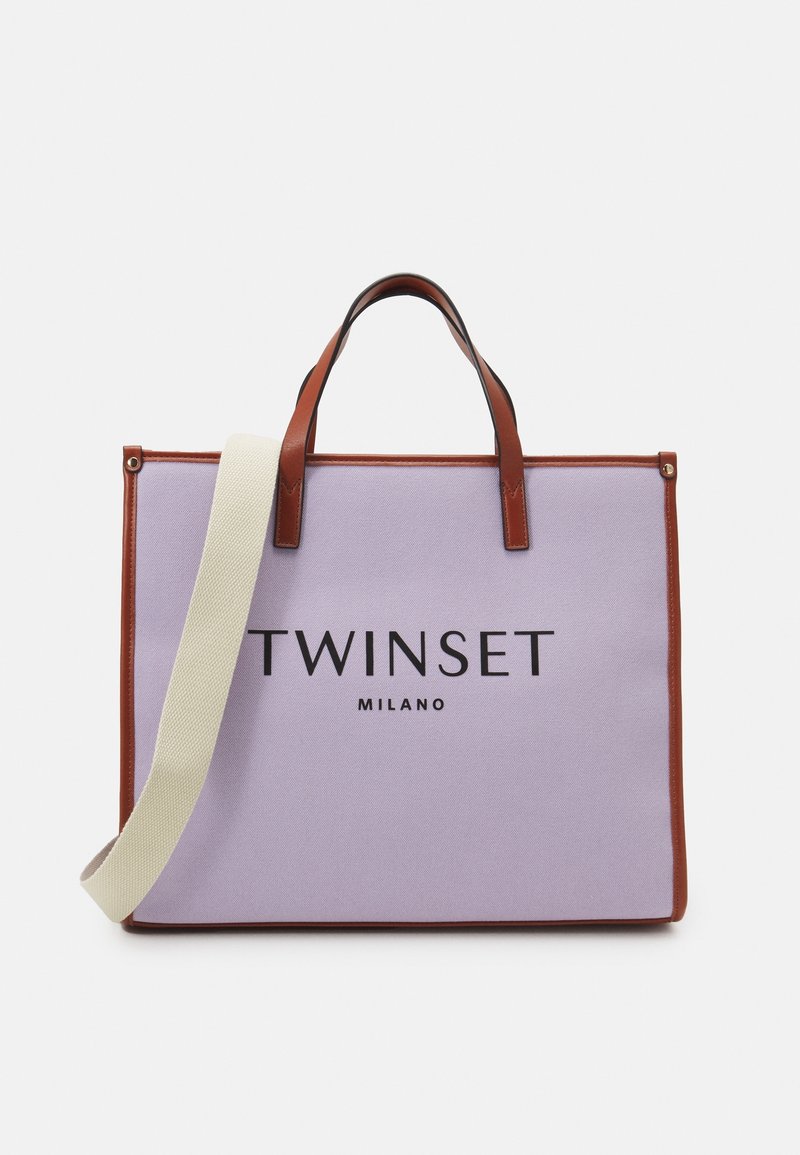 Sac fourre-tout en toile lavande avec accents en cuir marron, doté de doubles poignées et d'une bandoulière beige amovible. "TWINSET MILANO" imprimé sur le devant.