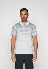 Šviesiai pilkos spalvos trumpo rankovio polo marškiniai, su taškinio rašto dizainu, kuris blyškėja link apačios. Įtrauktas stovo apykaklė ir logotipo paktas.