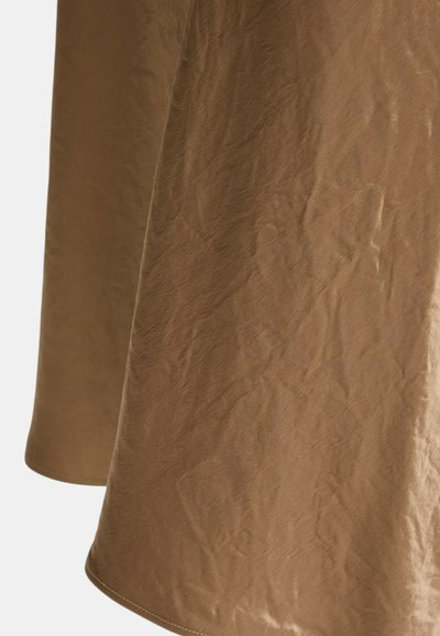 Tessuto marrone con una texture arricciata, caratterizzato da una finitura liscia e un orlo arrotondato. Il materiale appare leggero e morbido.