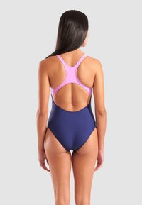 Navyblauwe badpak met roze accenten, voorzien van een racerback ontwerp en een open ruguitsnede, gemaakt van rekbare, gladde stof.