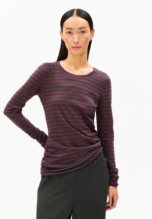 Langarmshirt in kastanienbraun und grau mit rundem Ausschnitt und strukturiertem Stoff, kombiniert mit dunkelgrauten Hosen, die ein gerafftes Design haben.