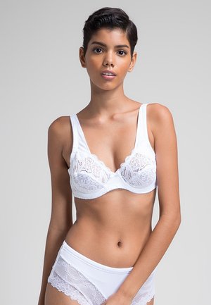 Sostén de encaje blanco con un diseño de copa suave, tirantes anchos y patrones florales intrincados. Combinado con braguitas a juego acentuadas con encaje.