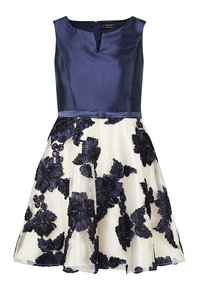 Klänning med marinblå satinöverdel och rundad halsringning. Krämfärgad kjol med stora marinblå blomsterbroderier. Uppsvept silhuett och dragkedja bak.