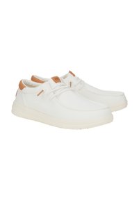 Scarpe da ginnastica bianche in tela con una superficie liscia, caratterizzate da dettagli in pelle beige e un design con lacci, montate su una suola in gomma di colore chiaro.