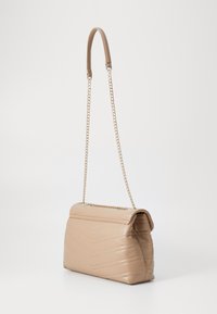 Borsa a mano in finta pelle beige con motivo a spina di pesce trapuntato, manico a catena e forma strutturata. Presenta una chiusura a pattina nella parte superiore.