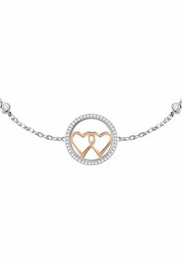 Bracciale in argento con un pendente circolare che presenta cuori intrecciati in oro rosa, circondati da piccole pietre trasparenti su una catena testurizzata.