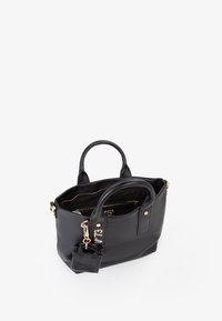 Bolso de mano de cuero negro con asas dobles, herrajes dorados y un interior con múltiples bolsillos. Presenta un charm y una superficie texturizada.