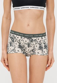 Virágmintás boxeralsó puha anyagból. Sötétzöld derékpánttal rendelkezik, rajta a "BJÖRN BORG" logóval és krém színű virágmintával.