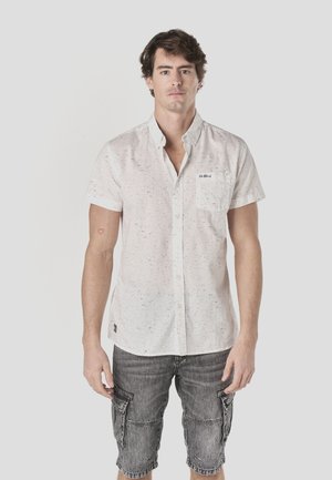 Weißes Kurzarmhemd mit strukturiertem Muster, Button-Down-Kragen und Brusttasche. Kombiniert mit grauen Cargo-Shorts.