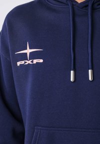 Navyblauwe hoodie met een voorzak, een capuchon met trekkoord en een roze geborduurd "PXP" logo met een ster ontwerp op de linkerborst.