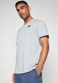 Under Armour HEAVYWEIGHT LEFT CHEST PATCH - Basic T-shirt - mod gray medium heather/black