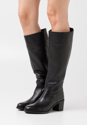 Černé kozačky ke kolenům z hladké kůže. Mají blokový podpatek a přiléhavý střih, s rovným horním okrajem a minimálním šitím.