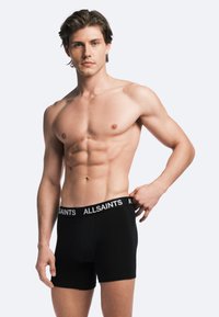 Svarta bomullskalsonger med en vit "ALLSAINTS"-logotyp på den elastiska midjebandet, med en åtsittande design och slät textur.