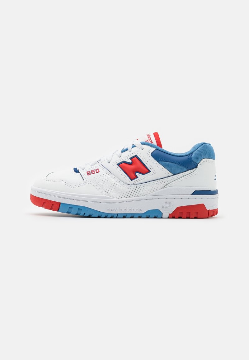 Baskets New Balance 550 blanches avec des accents rouges et bleus, col rembourré bleu, logo "N" rouge et semelle multicolore.