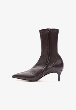 Brauner Leder-Stiefelette mit spitzer Zehenpartie, seitlichem Reißverschluss und schmal zulaufendem Absatz. Glatte Textur mit minimalen Nahtdetails.