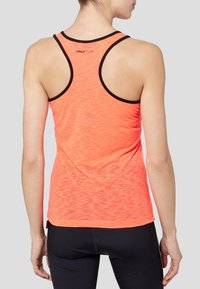Jasnopomarańczowy sportowy top na ramiączkach z teksturowanym wzorem, cienkim czarnym wykończeniem przy otworach na ramiona oraz z tyłem w stylu racerback.